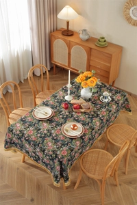 Detail of vintage floral tablecloth with fringe tassel edge and dark green pattern