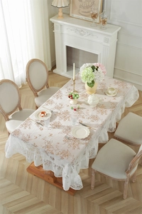 Détail du motif floral vintage et élégant bord à volants en dentelle sur nappe crème