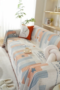 Detail of chenille sofa cover with orange blue stripes, star patterns and fringe