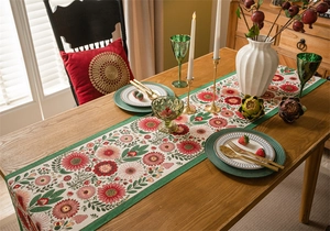 Detailed close-up of ethnic floral jacquard table runner with red flowers and green borders
