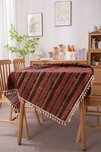Close-up of Bohemian striped tablecloth featuring retro patterns and white cotton tassels