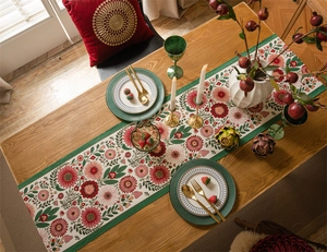 Detail of floral jacquard table runner with fringe on dark wood dining table set