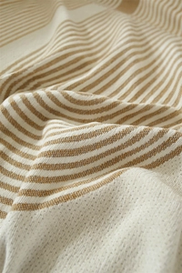 Détail macro du tissu jacquard en chenille montrant des rayures et une texture tissée
