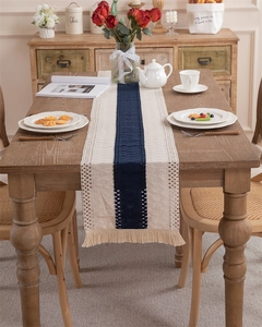 Detail of hand-woven cotton linen table runner with tassel fringe and striped texture