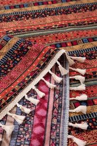 Detailed view of colorful geometric woven pattern and cream cotton tassels on the tablecloth