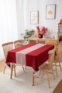 Detalle del mantel jacquard rojo con motivos de diamantes blancos y borlas decorativas