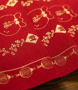 Close-up of festive red Chinese New Year table runner with gold jacquard lucky symbols