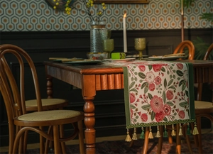 Dettaglio del runner da tavola jacquard con motivi floreali vintage e nappe con frange