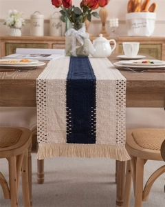 Close-up of handwoven blue and beige table runner with crochet hollow texture and tassels