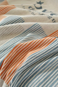Close-up of chenille sofa throw showing jacquard stripes and coarse woven texture details