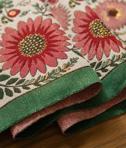 Detailed close-up of woven table runner featuring red daisy jacquard and gold threads