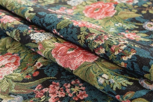Close-up of vintage floral jacquard fabric with golden fringe and thick woven texture
