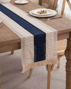 Detail of hand-woven cotton linen table runner with navy stripes and beige tassels