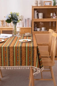 Detail of Bohemian striped tablecloth with gold foil patterns and white fringe edges