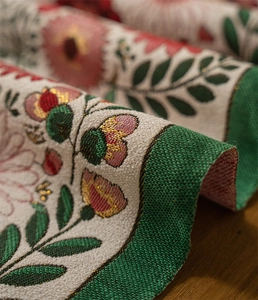 Detailed view of American retro floral jacquard fabric with thick green woven border