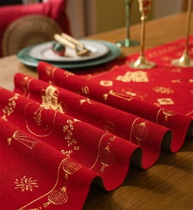Close-up of red festive table runner with golden embroidery and detailed jacquard texture