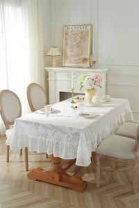 Détail d'une nappe en dentelle florale blanche avec bordures à volants et texture fine