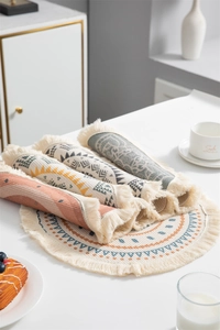 Détail d'un set de table rond avec motifs géométriques bohèmes et franges