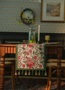 Dettaglio runner da tavola jacquard floreale rosso con nappe verdi e dorate