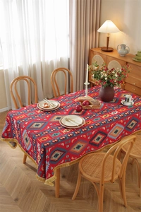 Close-up of bohemian floral geometric patterns and golden fringe tassels on table cloth