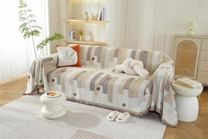 Close-up of Chenille sofa cover featuring Nordic star pattern, stripes, and fringe detail