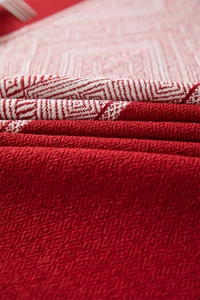 Primer plano de tela jacquard roja con patrones geométricos de diamantes y textura