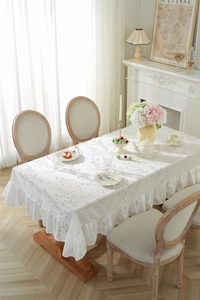 Détail du motif floral et des bords volantés sur nappe de style rustique français