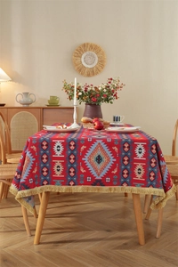 Detail of vintage bohemian tablecloth with geometric floral patterns and gold tassels