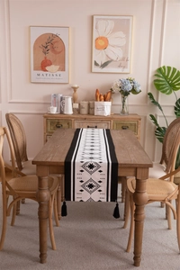 Detailed macro view of woven geometric diamond pattern and black tassels on table runner