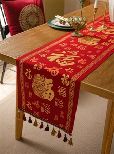 Detail of red Chinese New Year table runner with gold Fu character and colorful tassels