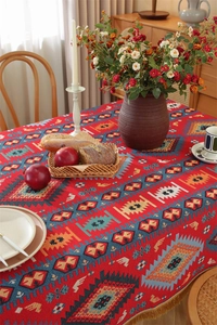 Close-up of bohemian red table runner with geometric patterns and golden fringe details