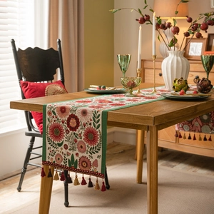 Elegant floral jacquard table runner with fringe tassels on solid wood dining table