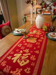 Close-up of red woven table runner with golden Fu character calligraphy and pattern