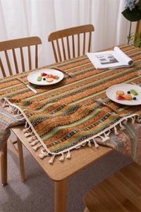 Close-up of Bohemian striped tablecloth with gold foil accents and white cotton tassels
