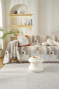 Detail of chenille sofa cover with star patterns and stylish fringe texture in a cozy room