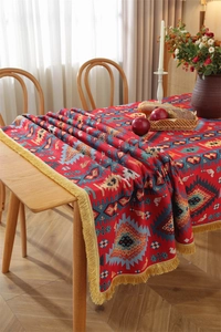 Close-up of bohemian red woven jacquard tablecloth with geometric patterns and yellow tassels