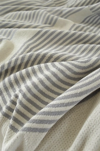 Gros plan sur la texture en chenille douce avec motifs de rayures géométriques gris et blanc