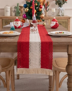 Detail of red and white woven Christmas table runner with tassels and hollow textures