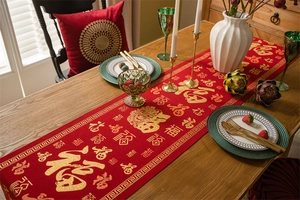 Macro shot of red jacquard table runner with golden Fu character and Greek key border