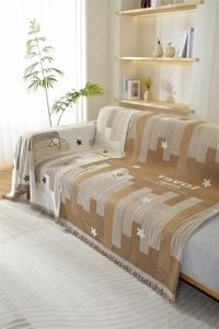 Detail of chenille sofa cover showing decorative star patterns and soft fringe tassels