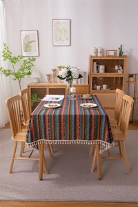 Detail of Bohemian striped tablecloth with gold foil accents and white fringe tassels