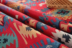 Close-up of woven jacquard fabric with geometric patterns and golden fringe details