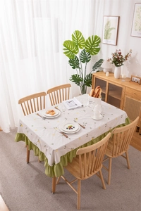 Detailed close-up of green ruffle edges and lemon floral patterns on a cotton tablecloth