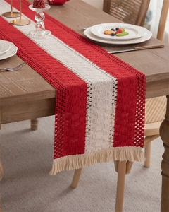 Detail of red and white woven cotton linen table runner with hollow texture and tassels