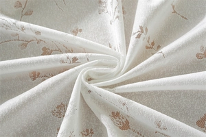 Détail de la nappe en dentelle blanche avec motifs floraux romantiques et bordures à volants