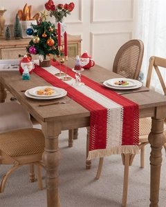 Detail view of red and white crocheted table runner with tassels for Christmas decor