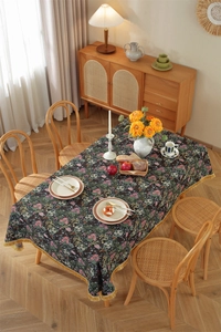 Detail of vintage floral jacquard tablecloth with elegant golden fringe tassels on edges