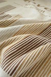 Detail of Nordic chenille sofa cover with woven stripes and artistic text elements