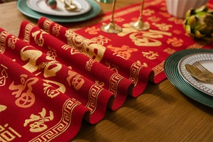 Detail of red Chinese New Year table runner with golden Fu character jacquard pattern