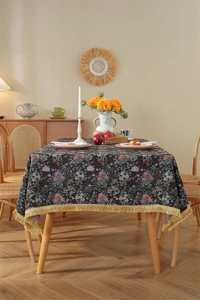 Close-up of vintage floral jacquard tablecloth with elegant golden tassel fringe edges